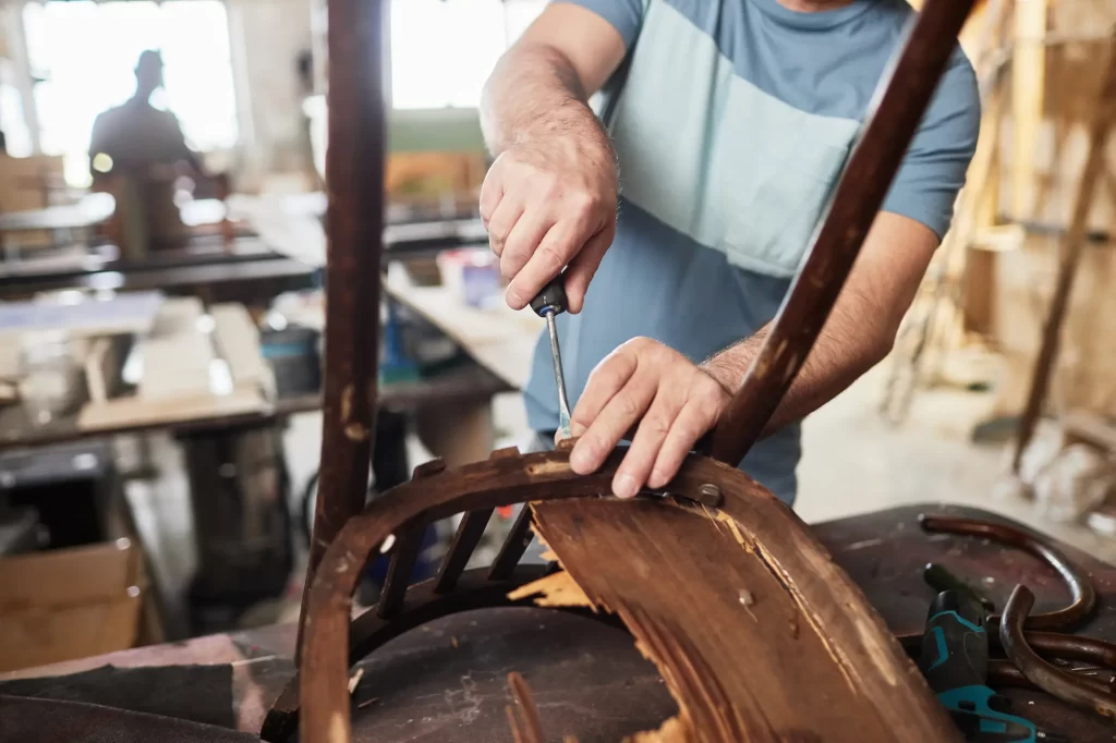 Persona realizando mantenimiento a una silla en un taller